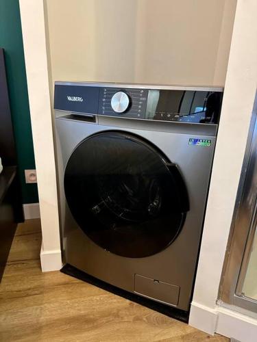 Un lave-linge est installé dans un coin de la pièce. dans l'établissement T2 avec parking privatif, à Toulouse
