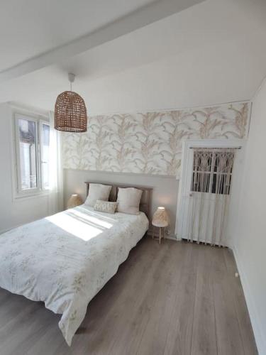 une chambre avec un grand lit dans une pièce dans l'établissement Maison de ville La Beauhème, à Beaulieu-sur-Loire