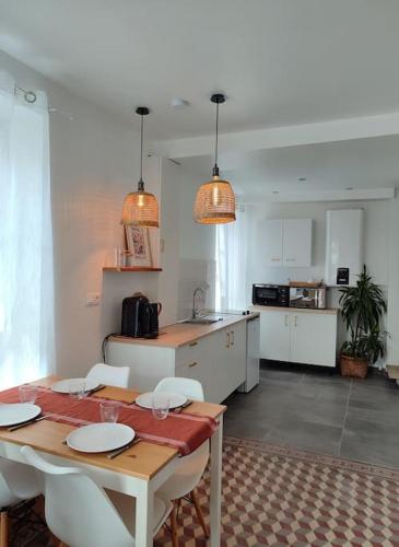 une cuisine avec une table et des chaises en bois ainsi qu'une cuisine avec une table et des chaises dans l'établissement Maison de ville La Beauhème, à Beaulieu-sur-Loire