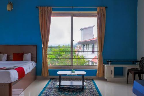 a bedroom with a bed and a large window at Green Premium Villa Ooty by Lexstays in Ooty
