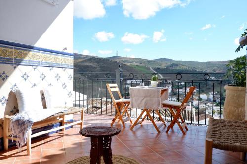 a patio with a table and chairs on a balcony at Casa Frasquita del Pan - Caminito del Rey in Valle de Abdalagís