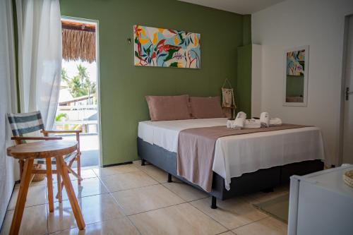 een slaapkamer met een bed met een tafel en een stoel bij Pousada Coconut Cumbuco in Cumbuco