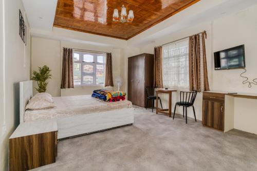 a bedroom with a bed and a desk and a table at Silvermist BnB in Shillong