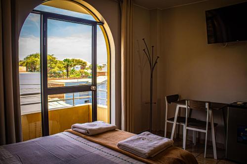 a bedroom with a bed and a table and a window at DEL VALLE HOUSE II in Ica
