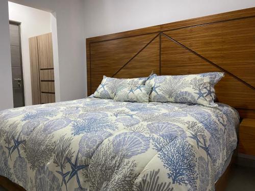 a bedroom with a bed with a wooden head board at Vacacional Bluú Hábitat Lagoons in Los Cerritos