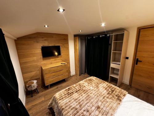 a bedroom with a bed and a dresser and a television at Chalet Millou Beuil in Beuil