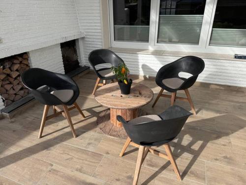 three chairs and a table with a potted plant on a patio at Nice Place in Löningen