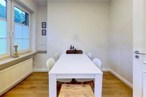 a white dining room with a white table and chairs at Nice Place in Löningen