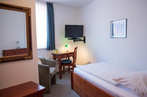 a bedroom with a bed and a mirror and a desk at Mahlzeit - Hotel Brauhaus Weyhausen - Keramikstudio in Weyhausen