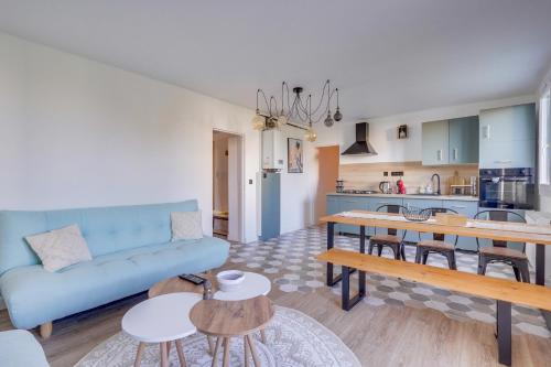 un salon avec un canapé bleu et une cuisine dans l'établissement Fridhome Jacuzzi Parking Wifi Fibre 2MIN Tram, à Bruges