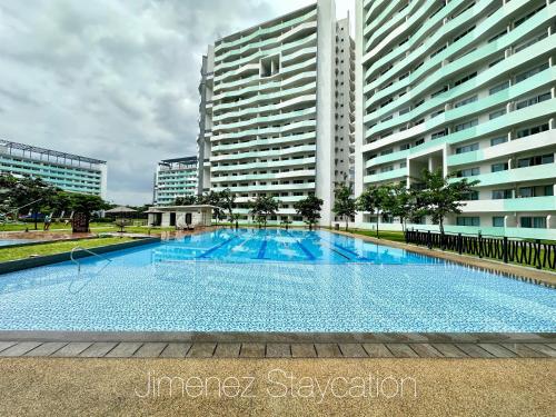 a large swimming pool in front of a large building at Jimenez Staycation Unit 406 Quirino west tower The Residence at Commonwealth by Century in Manila