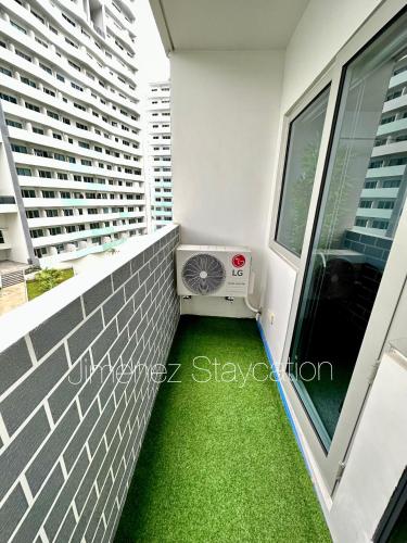 a balcony with green grass in a building at Jimenez Staycation Unit 406 Quirino west tower The Residence at Commonwealth by Century in Manila