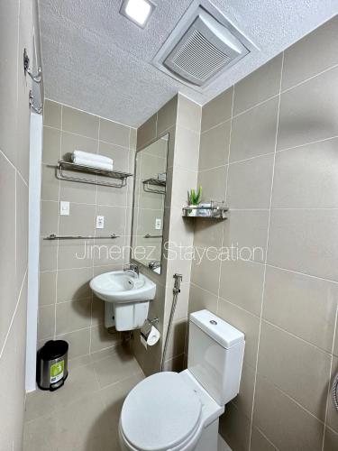 a bathroom with a white toilet and a sink at Jimenez Staycation Unit 406 Quirino west tower The Residence at Commonwealth by Century in Manila