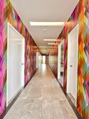 a hallway with colorful wall murals in an office building at Jimenez Staycation Unit 406 Quirino west tower The Residence at Commonwealth by Century in Manila