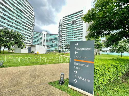 a sign in a park with buildings in the background at Jimenez Staycation Unit 406 Quirino west tower The Residence at Commonwealth by Century in Manila