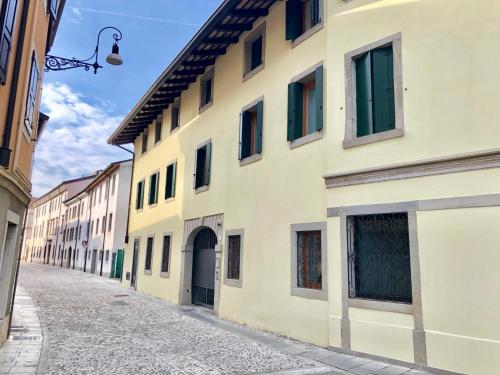 an alley in an old town with yellow buildings at Udine Center Apartment in Udine
