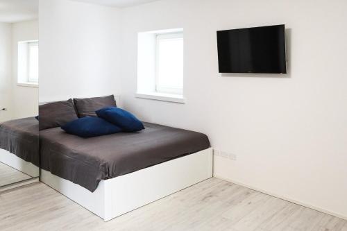 a room with a bed with a tv on a wall at Udine Center Apartment in Udine