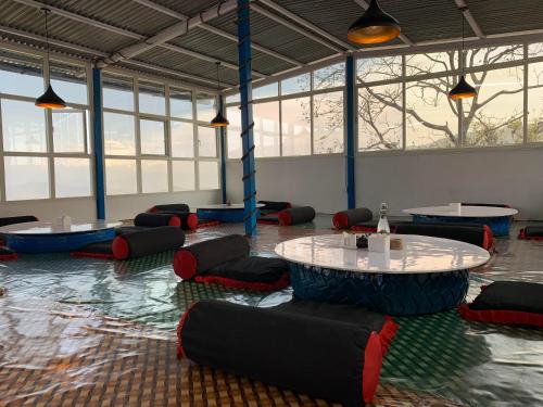a room with a table and chairs and windows at sanjivani buti organic krisi farm & resort in Nagarkot