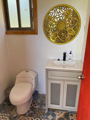 a bathroom with a toilet and a sink at Casa Costa Zapallar in Catapilco