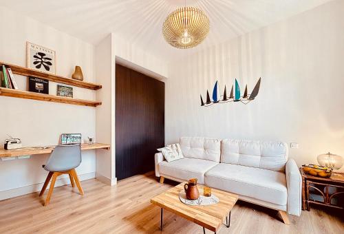 un salon avec un canapé blanc et une table dans l'établissement Charming 2-Bedroom Retreat Near City Center with Excellent Transport Links, à Nice