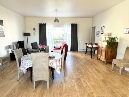 un salon avec une table et des chaises dans l'établissement La Maison bleue - Plain-Pied proche plages et Caen, à Rosel