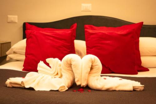 a bed with red pillows and a swan made out of blood at B&B Aquino in Terrazza in Aquino