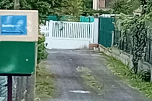 a street with a fence and a white gate at coin tranquille in Pont-du-Château