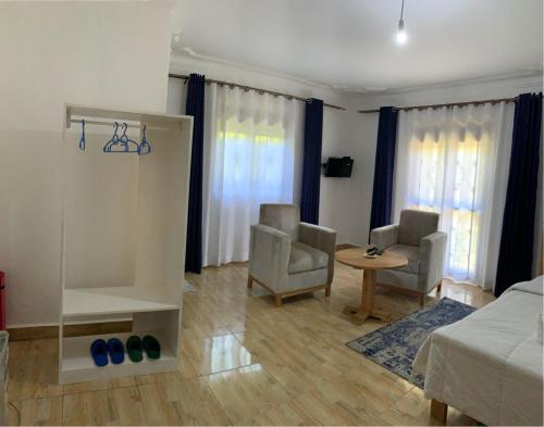 a living room with a bed and two chairs and a table at Fun-Ville Vacation Home, 4 bedrooms - Entire Home in Butebe