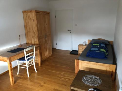 a bedroom with a bed and a desk and a table at Appartementhaus AdiS in Aresing