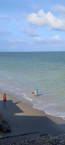 two people playing in the water at the beach at Pousada Di Ponta in Goiana
