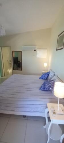 a large bed with blue pillows in a room at Pousada Di Ponta in Goiana