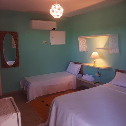 a hotel room with two beds and a lamp at Pousada Di Ponta in Goiana