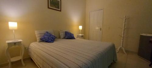 a bedroom with a large bed with blue pillows at Pousada Di Ponta in Goiana