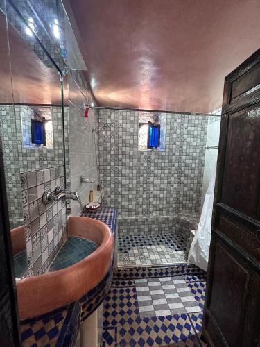 a bathroom with a tub and a tiled shower at Villa privée Wafa in Marrakesh