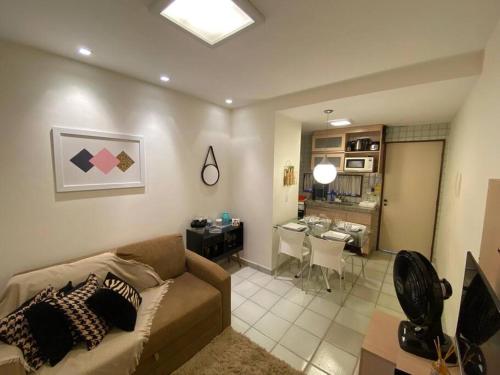 a living room with a couch and a dining room at Flat Monte Castelo - Gravatá in Bezerros