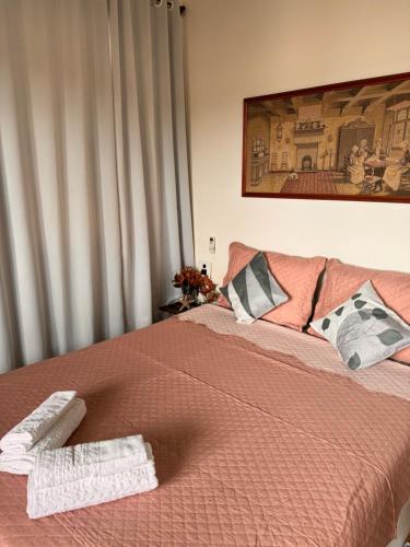a bedroom with a bed with two towels on it at Pousada Casa de Buzios in Búzios