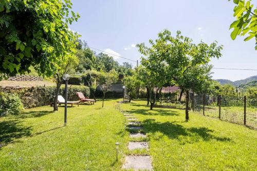 a garden with a bench and trees in the grass at VILLA ATRIS in Borghetto di Vara