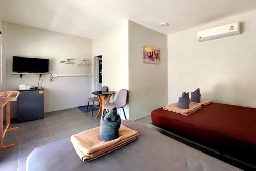 a room with a bedroom with a bed and a table at Davy Cottage Phuket in Ban Riang