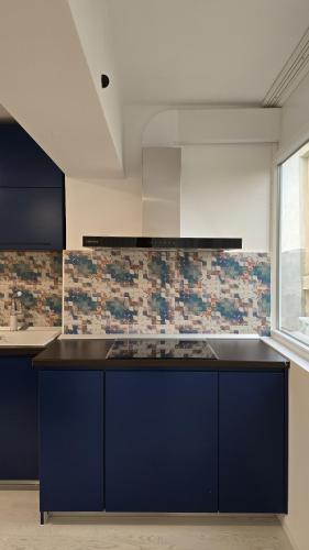 a kitchen with blue cabinets and a counter top at La Nr 17 in Cernavodă