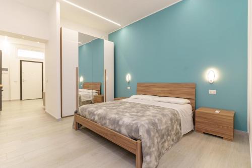 カターニアにあるAthena Apartamentの青い壁のベッドルーム1室(大型ベッド1台付)
