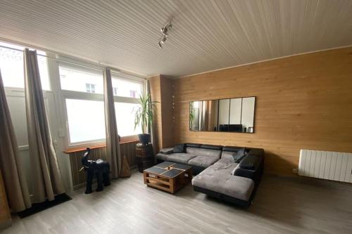un salon avec un canapé et une table dans l'établissement Appartement chaleureux avec terrasse en centre ville proche mer, à Saint-Nazaire
