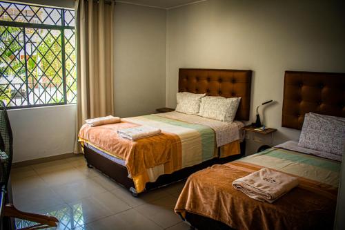 a bedroom with two beds and a window at DEL VALLE HOUSE II in Ica