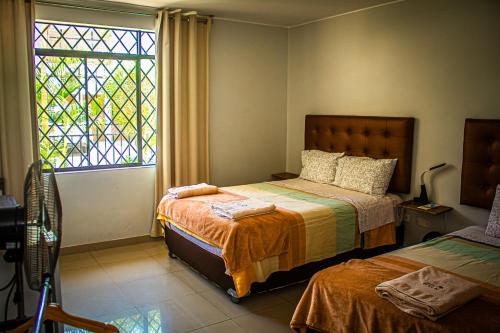 a bedroom with two beds and a window at DEL VALLE HOUSE II in Ica