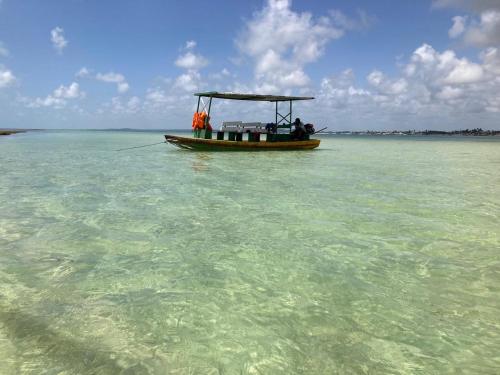 a small boat in the water in the ocean at Pousada Di Ponta in Goiana