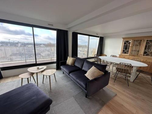 un salon avec un canapé et une table dans l'établissement Lumineux Duplex - Hyper Centre - Terrasse, à Reims