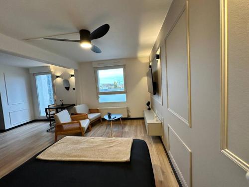 a living room with a couch and a ceiling fan at Charmant Studio Neuf, Hypercentre, Parking, Balcon in Strasbourg