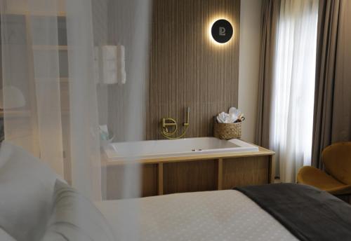 a bedroom with a tub and a bed and a mirror at Hotel Puerto de Luarca in Luarca