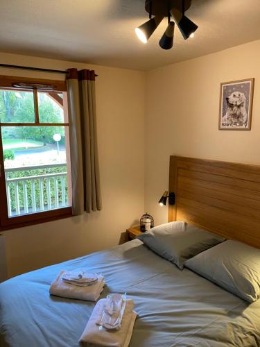 a bedroom with a bed with two towels and a window at Appartement T2+coin nuit 6 pers résidence de Cami Real au centre du village de saint Lary Soulan avec piscine intérieure+ sauna et hammam in Saint-Lary-Soulan
