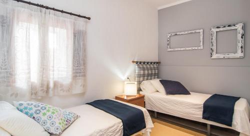 a bedroom with two beds and a window at Finca Can Tiro in Costitx