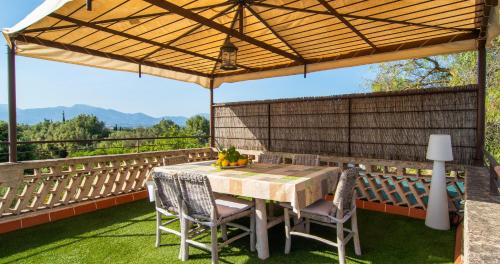 a table and chairs under a canopy on a patio at Finca Can Tiro in Costitx